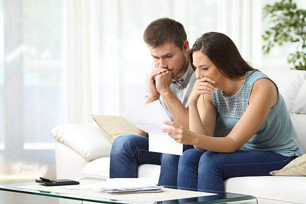 Stressed couple reviewing bills